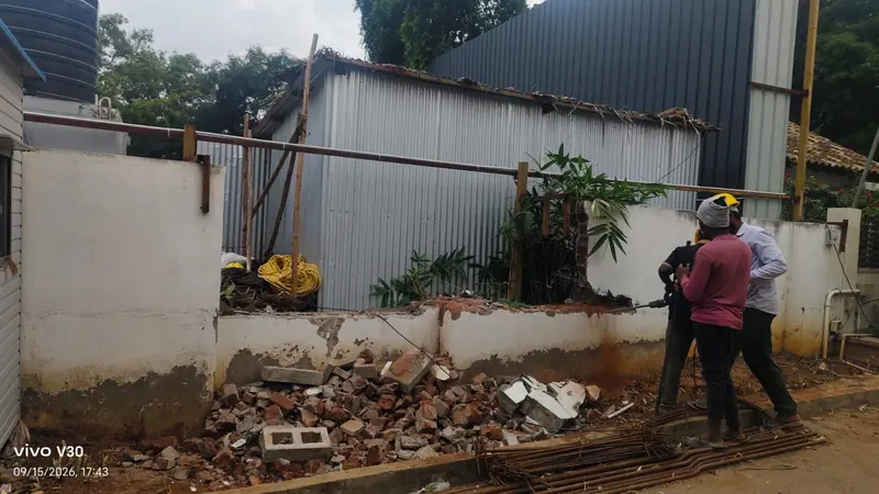 Workers breaking a compound wall in Coimbatore